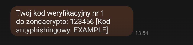 Zrzut ekranu wiadomości SMS, w której użytkownik otrzymał kod weryfikacyjny. Wiadomość brzmi: "Twój kod weryfikacyjny nr 1 do zondacrypto: 123456 [Kod antyphishingowy: EXAMPLE]". Obok wiadomości widoczny jest również czas jej otrzymania: 13:54.